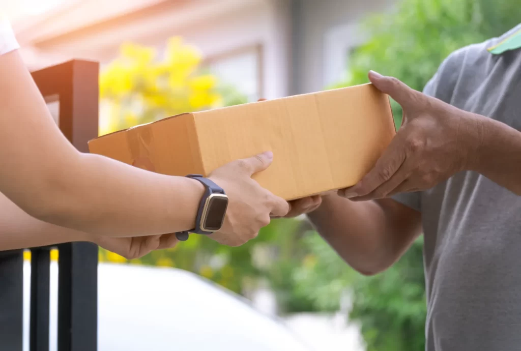 woman s hand receiving a parcel box from deliverym utc ()